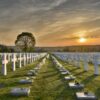 soldatenfriedhof mit unendlich vielen weissen kreuzen bis zum horizont bei sonnenuntergang