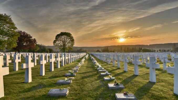 soldatenfriedhof mit unendlich vielen weissen kreuzen bis zum horizont bei sonnenuntergang